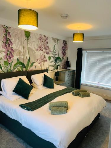 a bedroom with two beds with towels on them at White Horses Anglesey in Newborough