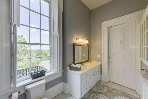 een badkamer met een wastafel, een spiegel en een raam bij The Duff Green Mansion in Vicksburg