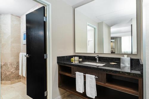 un bagno con lavandino e specchio di Krystal Urban Aeropuerto Ciudad de Mexico a Città del Messico