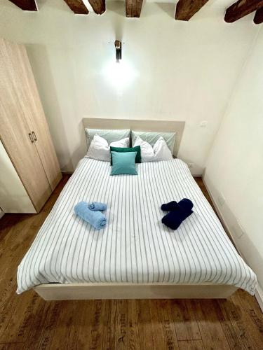 a large white bed with two blue pillows on it at RESIDENCE ZAR - 2 in Trieste