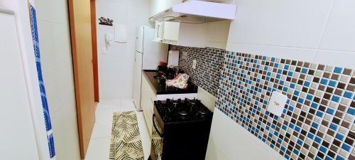 a small kitchen with blue and white tiles on the wall at Top Wave Itapoã 2 (702s) in Vila Velha