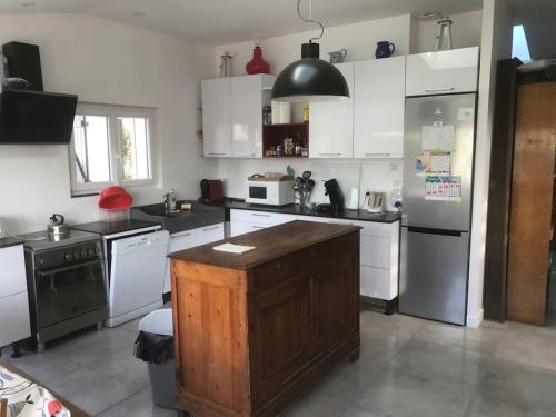 una cocina con armarios blancos y una isla de madera. en maison de vacances en bord de mer, en Saint-Hilaire-de-Riez