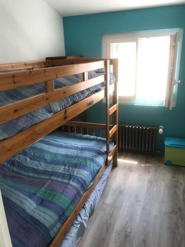une chambre avec deux lits superposés et une fenêtre dans l'établissement maison de vacances en bord de mer, à Saint-Hilaire-de-Riez