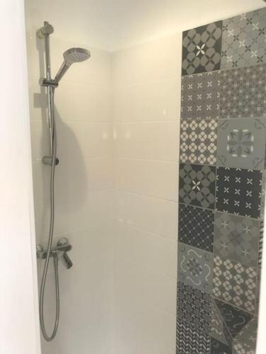 une douche dans une salle de bain avec un mur carrelé dans l'établissement maison de vacances en bord de mer, à Saint-Hilaire-de-Riez