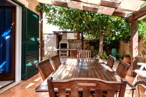 einen Holztisch und Stühle auf einer Terrasse in der Unterkunft Villa Aura in Marina di Modica