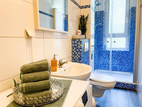 La salle de bains bleue et blanche est pourvue d'un lavabo et de toilettes. dans l'établissement Citynah, Balkon, große Küche und Garten, à Hanovre