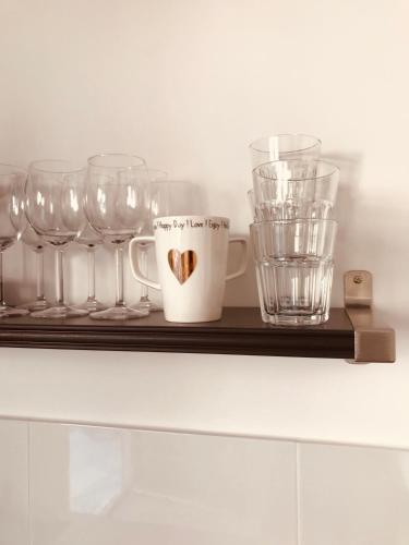a shelf with wine glasses and a cup on it at Studio - Les Traversières in Eymet