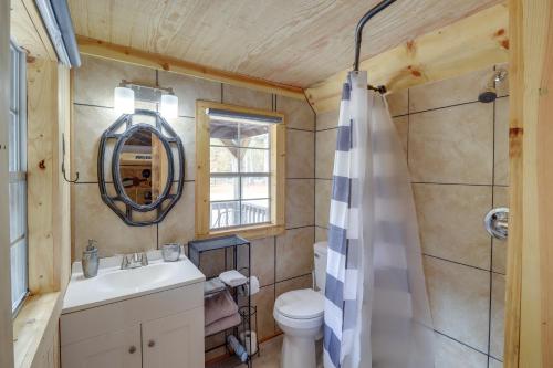 a bathroom with a sink and a toilet and a mirror at Tree-Lined Higden Retreat Close to Parks and Trails in Fairfield Bay