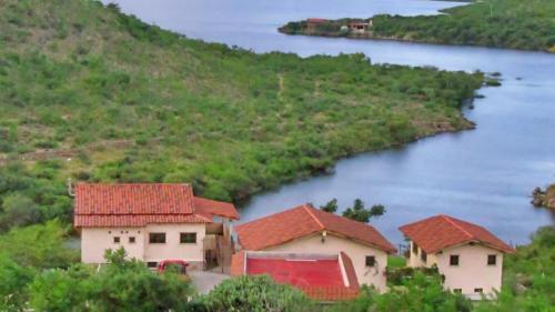 un grupo de casas en una colina junto a un río en Villa Campestre La Soledad en Colón