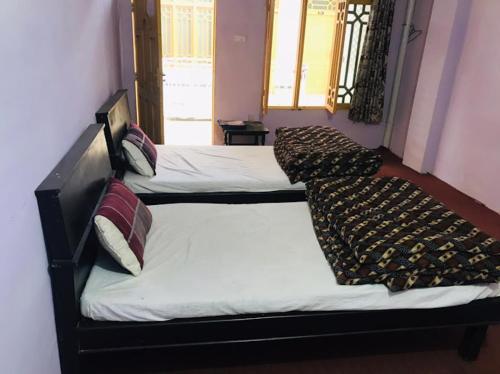 een slaapkamer met 2 bedden en kussens erop bij Sameer Hotel in Swat