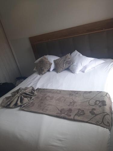 Una cama blanca con dos almohadas y una manta. en Appartement Anis, en Agadir