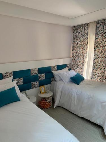 1 dormitorio con 2 camas y ventana en Appartement Anis, en Agadir