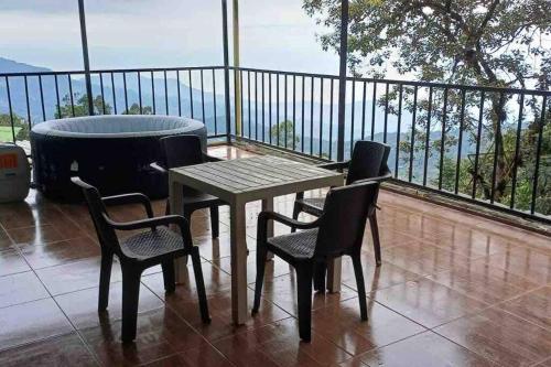 einen Tisch und Stühle auf einem Balkon mit Badewanne in der Unterkunft Ecocasa Impresionante panorámica jacuzzi Smart TV in Yumbo