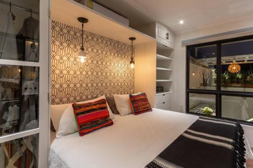 a bedroom with a white bed with two pillows on it at Casa Nico - a boutique home in Centro San Miguel in San Miguel de Allende