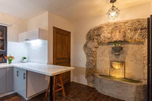a kitchen with a stone wall with a fireplace at Casa Nico - a boutique home in Centro San Miguel in San Miguel de Allende