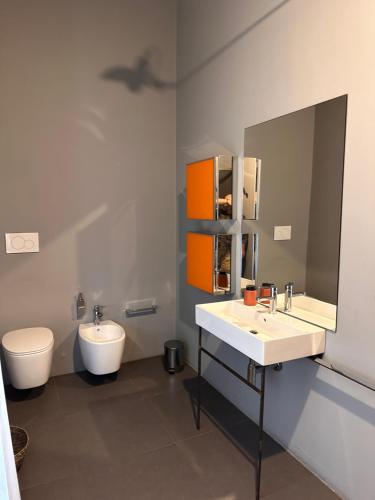 a bathroom with a sink and a toilet and a mirror at Botta 9 in Bergamo