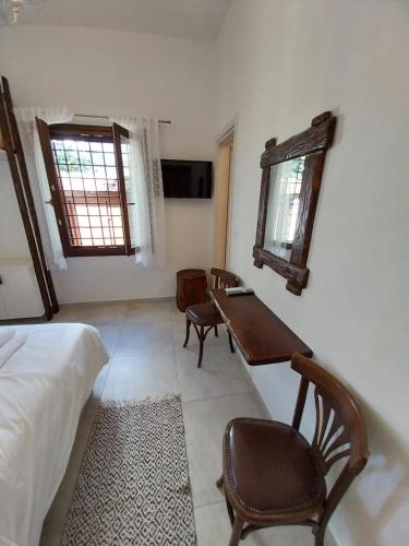 a bedroom with a desk and a bed and a table at Marousos Central Guesthouse in Portaria