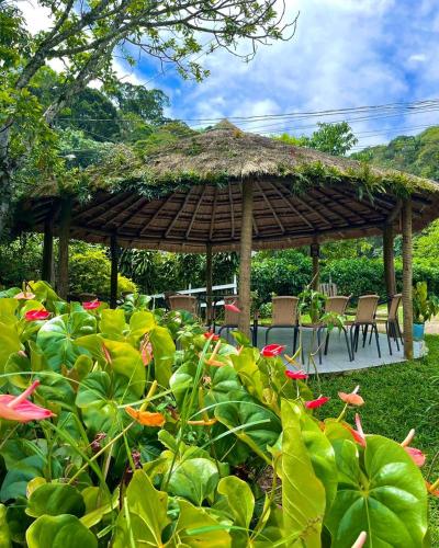 a gazebo with chairs and tables in a garden at Hotel Fazenda Rancho Mineiro in Engenheiro Paulo de Frontin