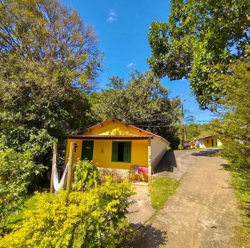 uma casa amarela com uma cerca ao lado de uma estrada em Hotel Fazenda Rancho Mineiro em Engenheiro Paulo de Frontin
