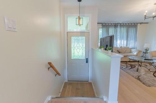 een hal die leidt naar een woonkamer met een deur bij Games BBQ with a upgraded stay near kawartha in Lakefield