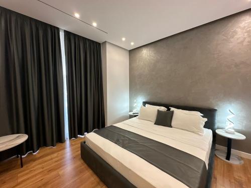 HOTEL UJVARA في Belsh-Qendra: غرفة نوم بسرير ونافذة كبيرة