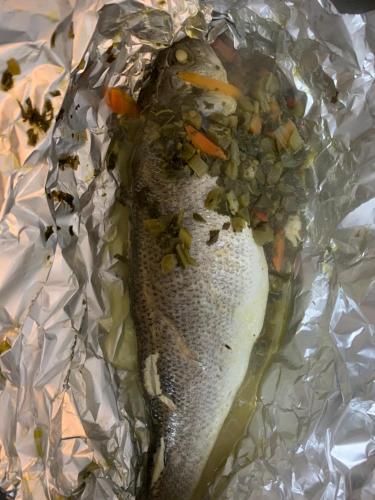 a fish wrapped in tin foil with vegetables on it at Peaceful Palms Montego Bay in Montego Bay