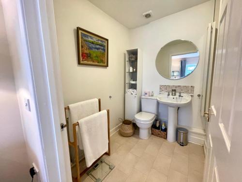 uma casa de banho com um lavatório, um WC e um espelho. em No 2 Ramageton em Troon