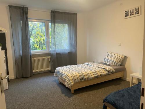 een slaapkamer met een bed en een raam bij Ferienwohnung in Saarbrücken in Riegelsberg