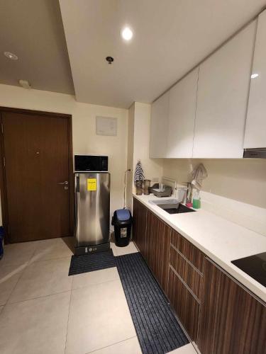 a kitchen with a stainless steel refrigerator and cabinets at Tambuli maribago residence in Lapu Lapu City