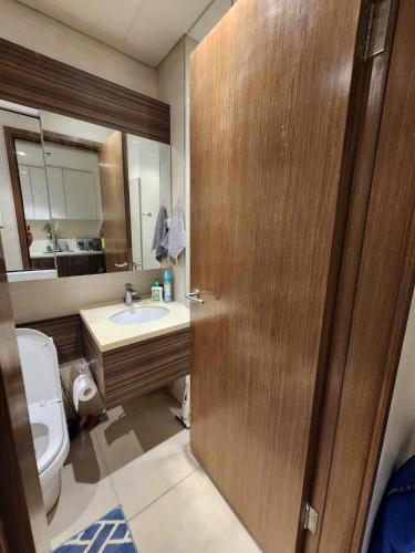 baño con aseo y lavabo y puerta de madera en Tambuli maribago residence en Lapu Lapu City