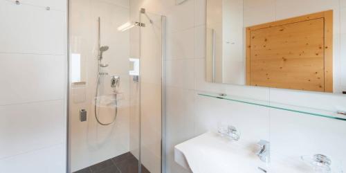 a bathroom with a shower and a sink and a mirror at Laudinella - Apart in See