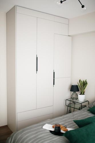 a bedroom with a bed with a large white closet at VIP apartments Bitola in Bitola