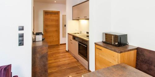 a small kitchen with a stove and a microwave at Laudinella - Apart in See