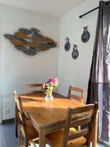 a dining room table with a vase of flowers on it at Maison Eugenie Arena, Gendarmerie, Rocade in Bouliac