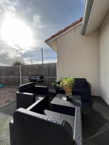 a patio with two black chairs and a table at Maison Eugenie Arena, Gendarmerie, Rocade in Bouliac