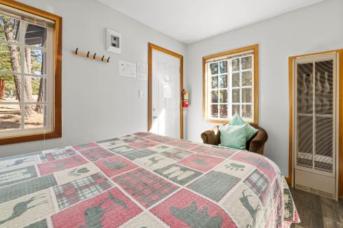 a bedroom with a bed and two windows at Baby Bear - A delightful studio style property in the perfect central location! in Big Bear Lake