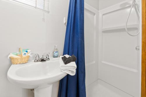 a bathroom with a sink and a blue shower curtain at Baby Bear - A delightful studio style property in the perfect central location! in Big Bear Lake