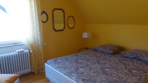 a bedroom with a bed and two mirrors on the wall at Eifelidylle am MoselMaareRadweg in Wittlich