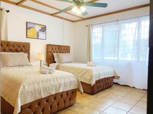 a bedroom with two beds and a ceiling fan at CASA 8 Bed&Breakfast in San José