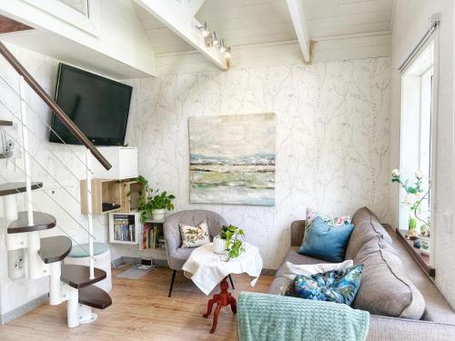 a living room with a couch and a tv at The Blomsholm Cabin in Strömstad