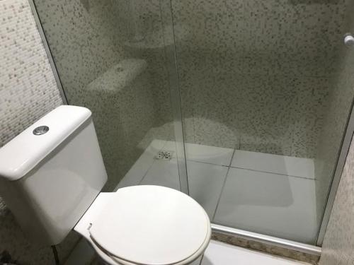 a bathroom with a white toilet and a shower at Pousada das Colonias Ilha da Gijóia in Barra da Tijuca