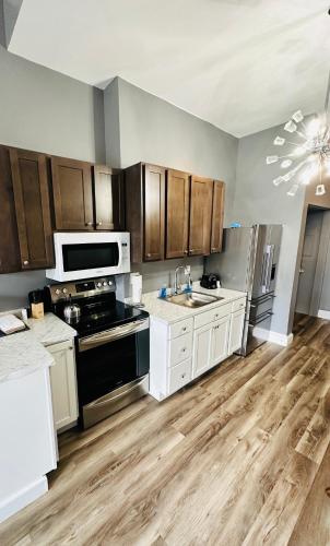 une cuisine avec des armoires blanches et des appareils noirs dans l'établissement Spacious Apartment Downtown Albany, NY, à Albany