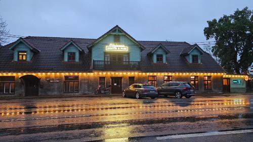 a building with two cars parked in front of it at Märjamaa Hostel in Märjamaa