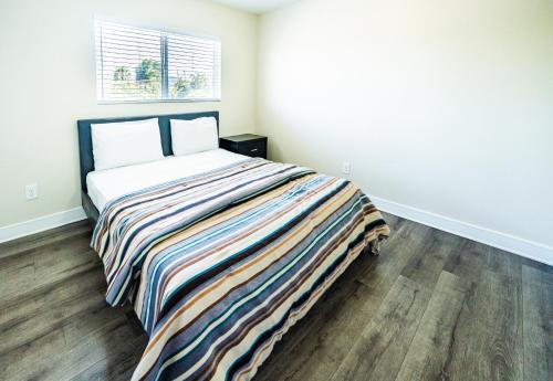 a bedroom with a bed with a striped blanket at Large chic 5-bedroom 3 bathroom clost to Downtown LA in Los Angeles
