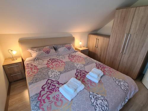 a bedroom with a bed with two towels on it at Vila Jovana - self check in in Čačak