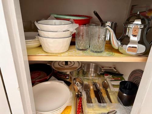 - une étagère de cuisine avec de la vaisselle et des ustensiles dans l'établissement Studio de charme Centrale Rabat, à Rabat