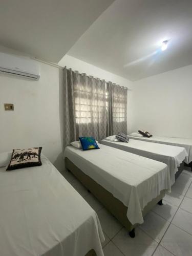 1 Schlafzimmer mit 2 Betten und einem Fenster in der Unterkunft Temporada CG - Casinha da Vovo in Campina Grande