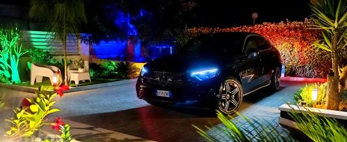 a car with its lights on parked in a driveway at Kemilia Matera in Matera