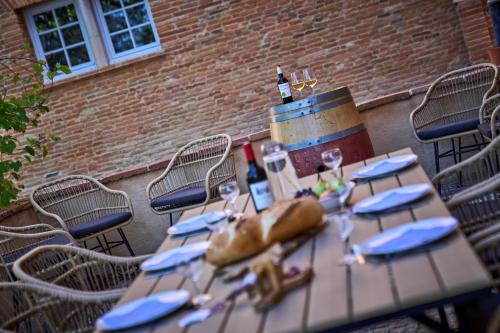- une table en bois avec des serviettes bleues et des verres à vin dans l'établissement Le Pastel, à Roquemaure