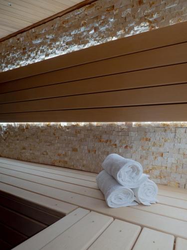 a stack of towels sitting on a bench at Luxurious Family Villa with sauna big garden and jacuzzi in Zeewolde